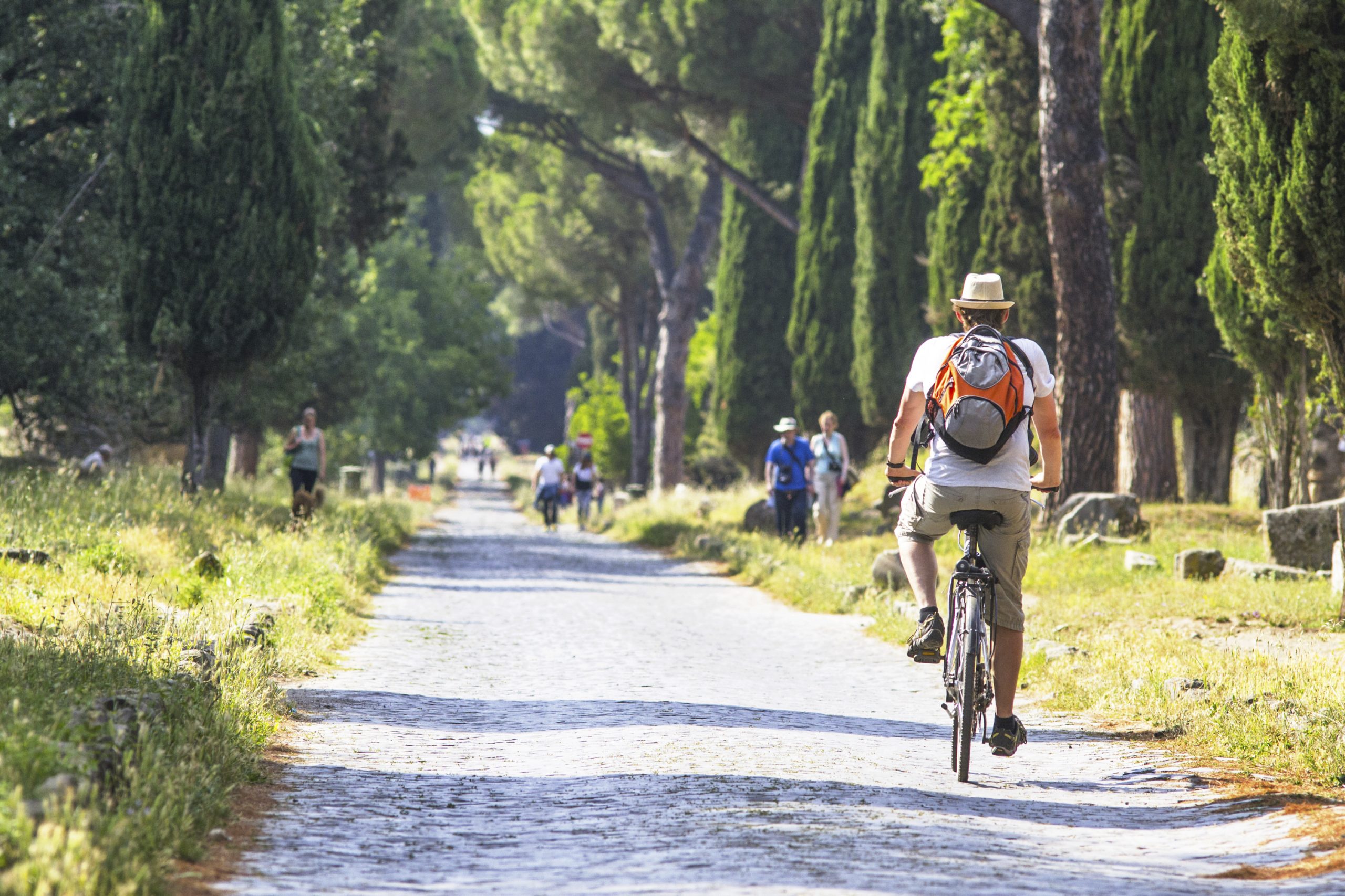 Cycliste parcourant l'ancienne voie Appia Antica à Rome sur un vélo de location