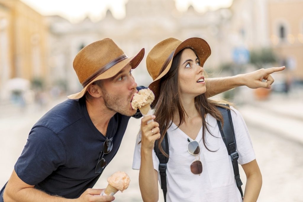 Rome en été avec un chapeau pour se protéger du soleil et un gelato italien pour se rafraîchir.